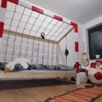 Łóżko bramka piłkarska Paco Design w pokoju dziecka z czerwoną siatką i sportowymi dodatkami