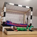 Dwoje dzieci bawiących się przy łóżku bramka piłkarska Paco Design z wysuwaną szufladą