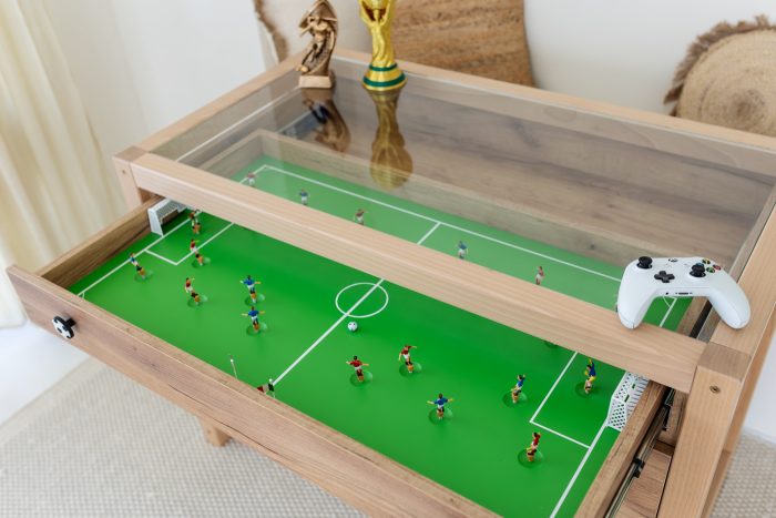 Detal biurka piłkarskiego Paco Design - wysuwana szuflada z boiskiem do gry w piłkarzyki pod szklanym blatem